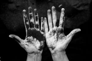 looking down at palms of hands covered in dirt - black and white - stigma of addiction