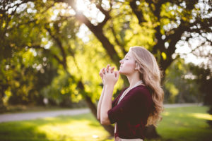 beautiful blonde woman praying outdoors - christian drug rehab