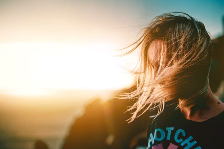 sandy blonde woman with hair blowing in face near beach - dual diagnosis