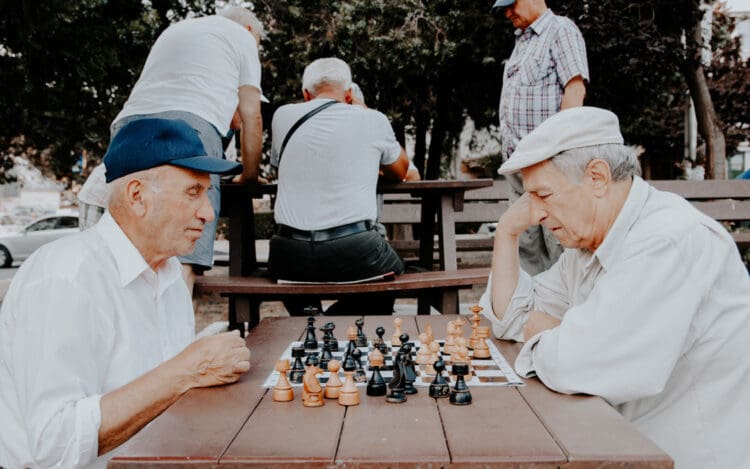 elderly gentlemen playing a game of chess in the park - alcohol abuse in the elderly