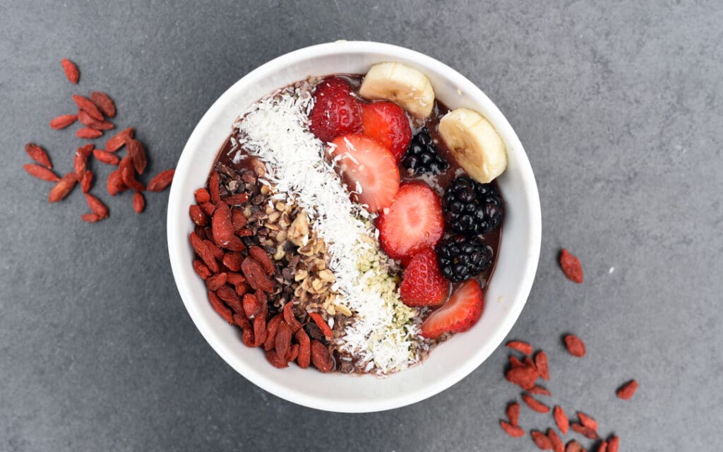 white bowl of berries and banana with oats - healthy after addiction rehab