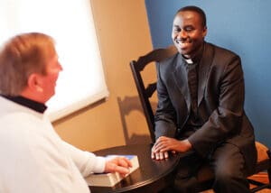 older man talking to African American preacher or minister