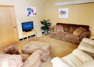 Tan room with one couch and several recliners