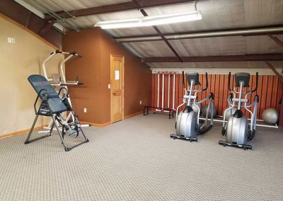 indoor gym area with inversion table and 2 elliptical machines