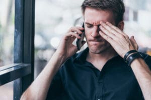 frustrated man upset talking on mobile phone - signs of relapse