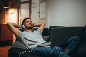 young man relaxing and listening to headphones - music and recovery