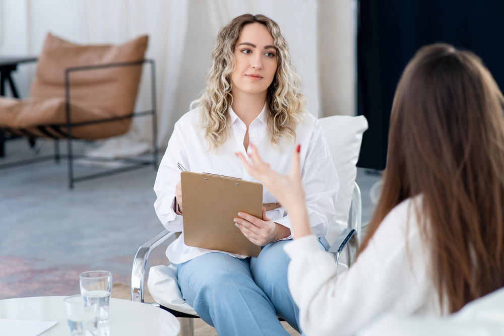 clinician talking with a client and taking notes