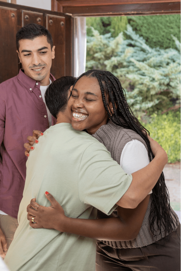 A woman hugging friends.